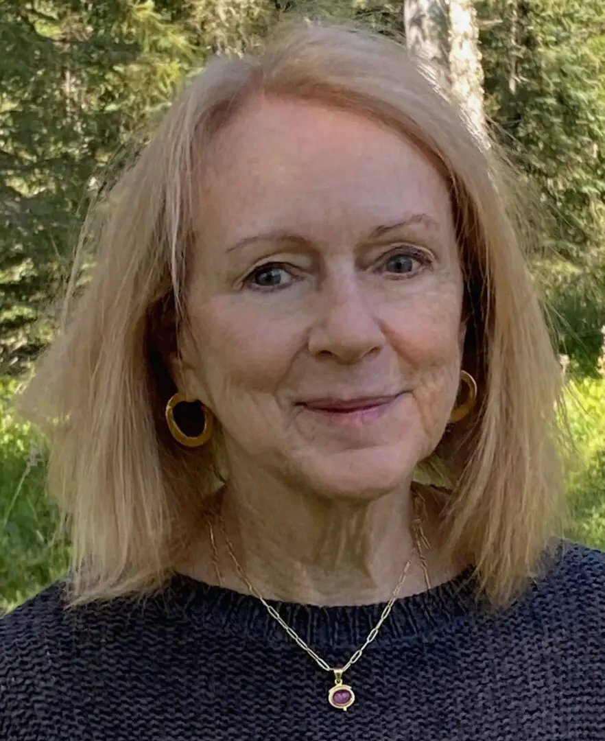 Woman with blonde hair in natural setting.
